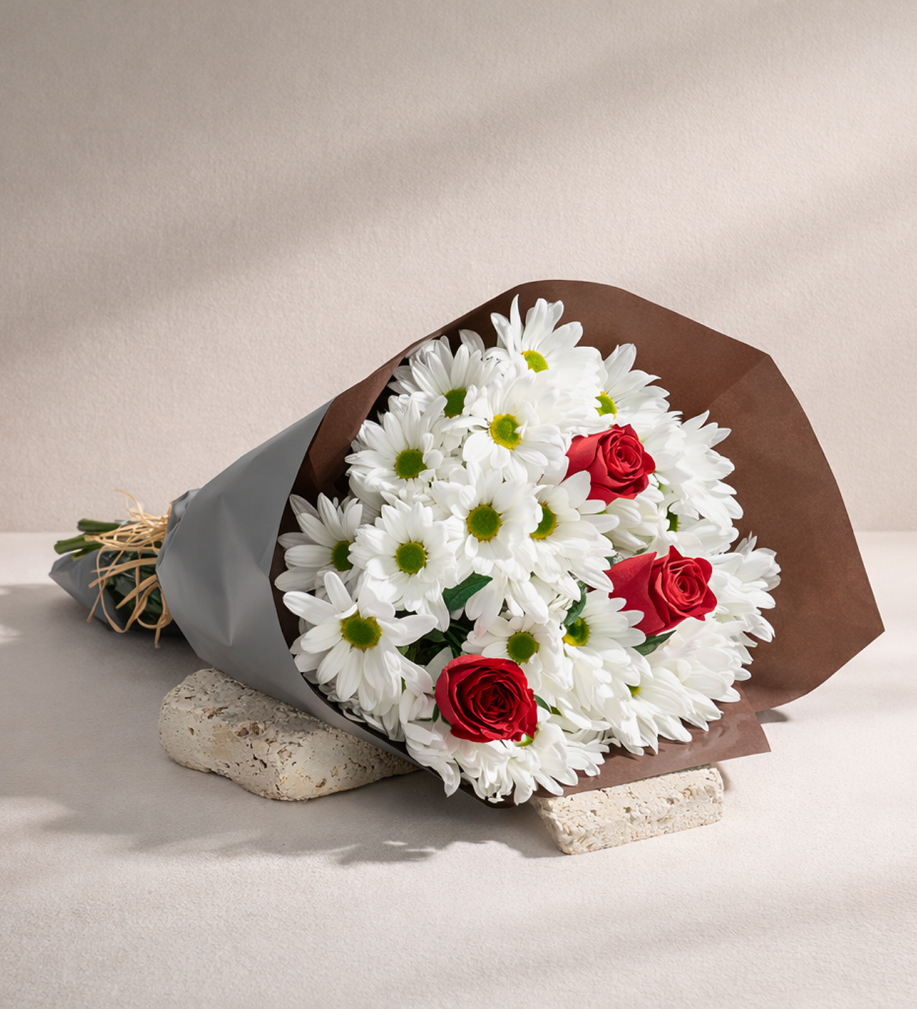 Red Roses & Daisies in Green-Brown Wrap, Three red roses with white daisies, eucalyptus and raffia, wrapped in a two-tone green-brown paper, standing 30 to 40 cm tall.