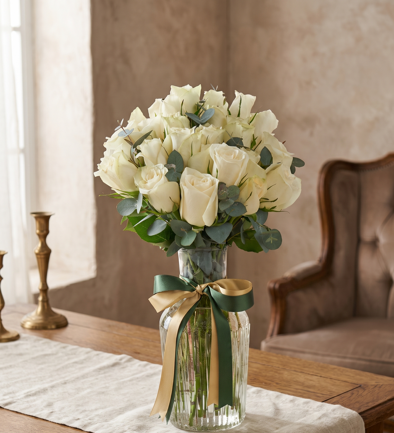 25 White Roses in a Striped Glass Pitcher Vase, Twenty-five white roses in a striped glass pitcher vase with dark green and gold-trim ribbons and fresh eucalyptus, 21.5 cm tall.