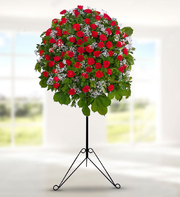 35 Red Roses and Eucalyptus Funeral Wreath on Stand, A round funeral arrangement of thirty-five red roses with eucalyptus and baby's breath on a black wrought-iron stand, 98 cm tall, to send condolences in Istanbul.