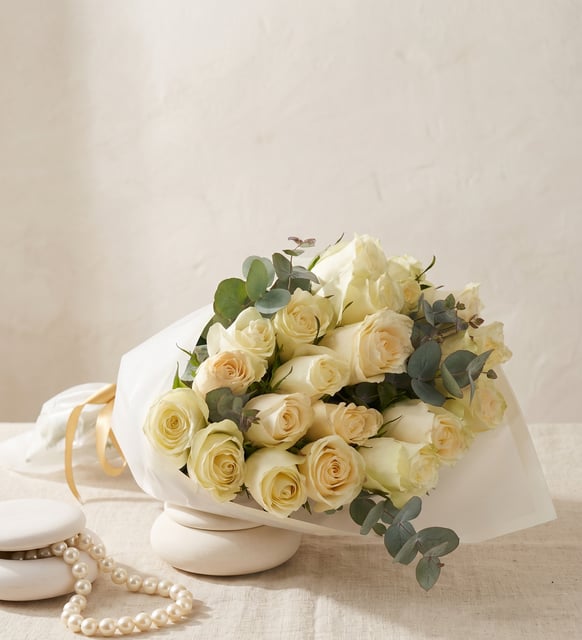 20 Roses Blanches en Papier Blanc Liseré, Vingt roses blanches avec de l'eucalyptus dans un papier blanc au bord liseré de blanc, de 30 à 40 cm de haut, un bouquet pur et élégant.