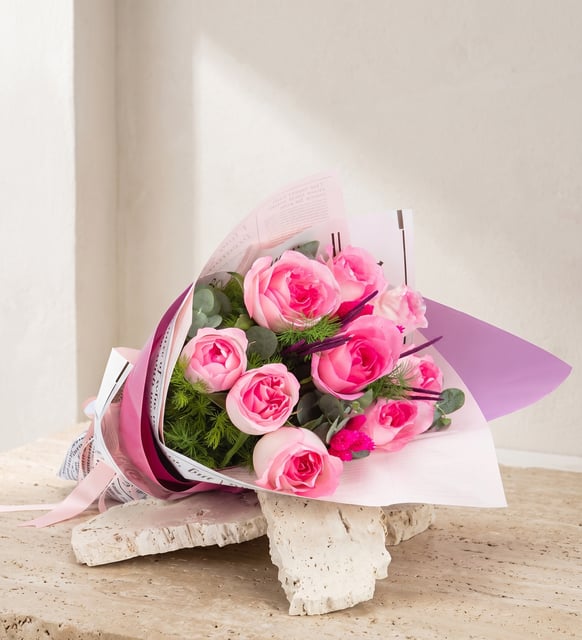 9 rosa Rosen im flieder-rosa Strauß, Neun rosa Rosen mit Eukalyptus und zartem Grün, in rosa Zeitungspapier und flieder-rosa Papier eingeschlagen, mit hellrosa Band.