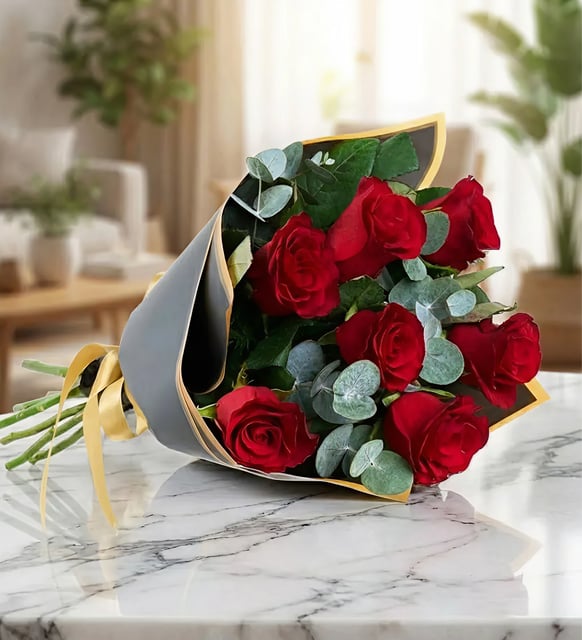 Strauß mit 7 roten Rosen, Sieben rote Rosen mit Eukalyptus in anthrazitfarbenem Papier mit Goldrand, mit goldenem Band gebunden.
