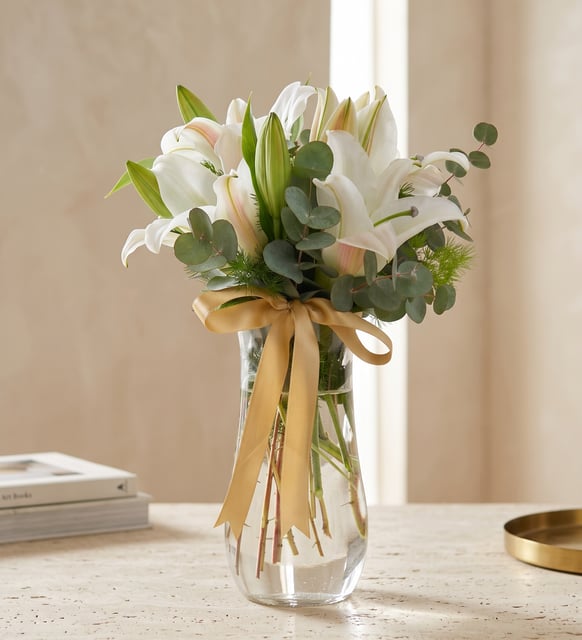 Lys Blancs dans un Vase en Verre, Ruban Doré, Des lys blancs avec de l'eucalyptus dans un vase en verre transparent, noués d'un ruban pailleté d'or, sobres et élégants.